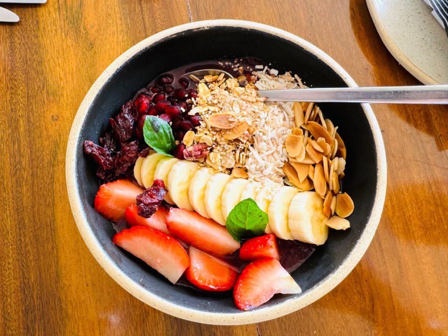 A huge breakfast bowl full of oatmeal, flax, chia seeds, and fresh mixed fruit with yogurt.